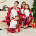 Famille en pyjama de Noël assorti haut blanc et pantalon à carreaux rouges et noirs